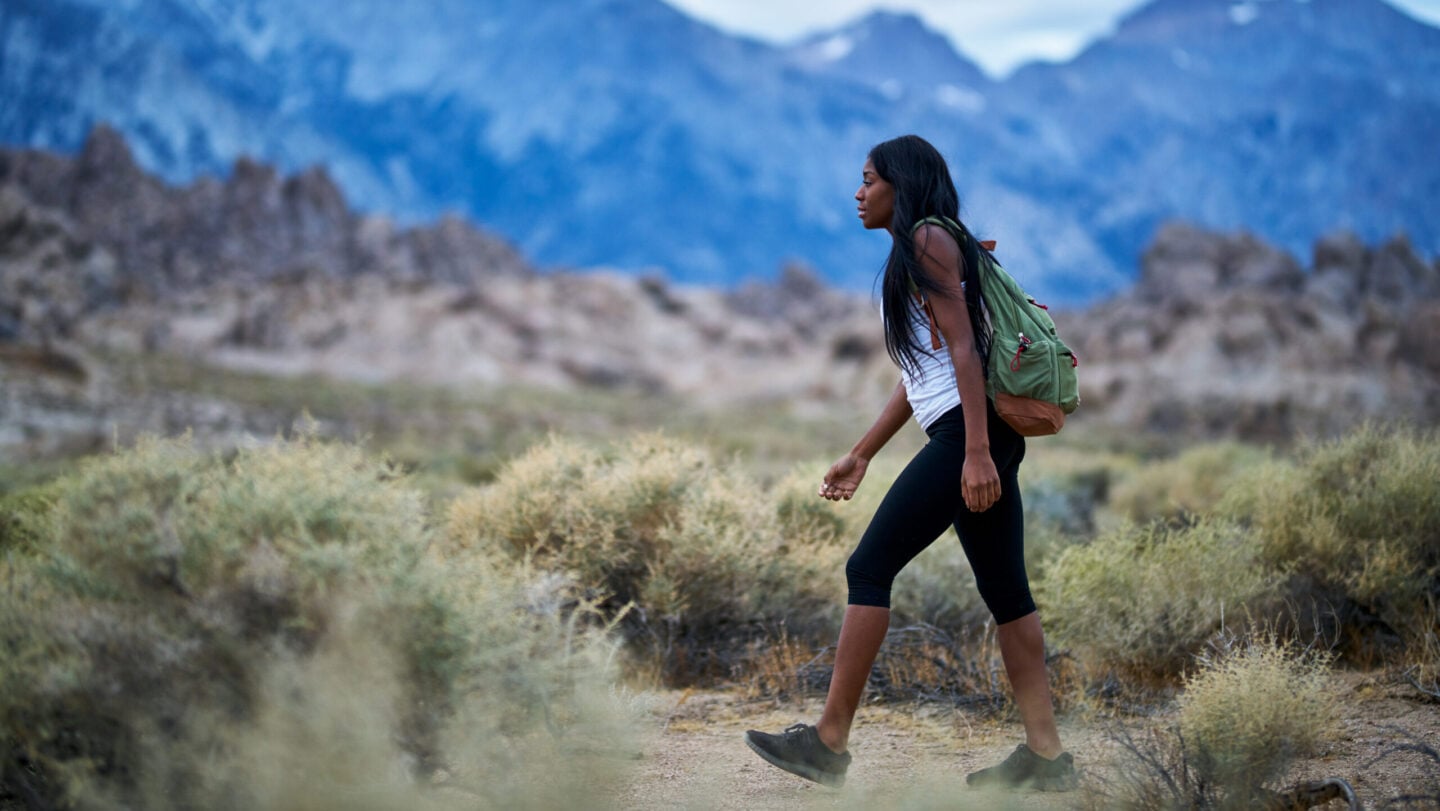 fit african american woman hiking through alabama hills park in california